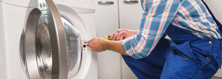 A repair man fixing a dryer